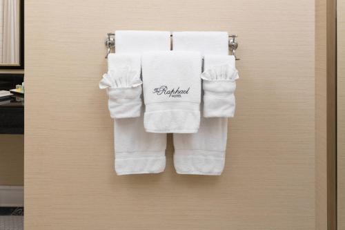 un grupo de toallas blancas colgando de una puerta en The Raphael Hotel, Autograph Collection en Kansas City