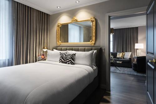 a bedroom with a large bed and a mirror at Hotel LeVeque, Autograph Collection in Columbus