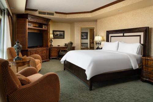 a bedroom with a large bed and a television at Renaissance Tulsa Hotel & Convention Center in Tulsa