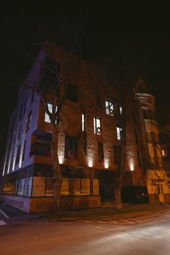 duży ceglany budynek z oświetleniem w nocy w obiekcie 26 Bricks Suites w mieście Oradea