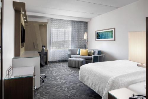 a hotel room with a bed and a couch at Courtyard by Marriott Orlando South/Grande Lakes Area in Orlando