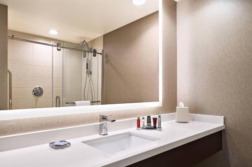 a bathroom with a sink and a large mirror at Pittsburgh Marriott North in Cranberry Township