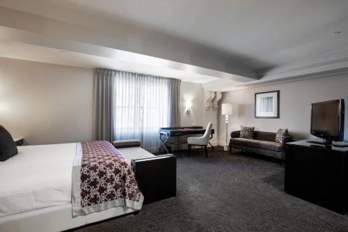 a hotel room with a bed and a couch and a desk at Ambassador Hotel Kansas City, Autograph Collection in Kansas City