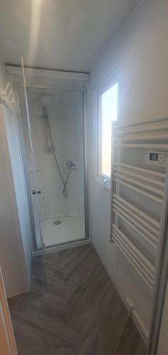 a bathroom with a shower with a glass door at Mobil home MAXI CONFORT SUR LA COTE D'AZUR in Fréjus