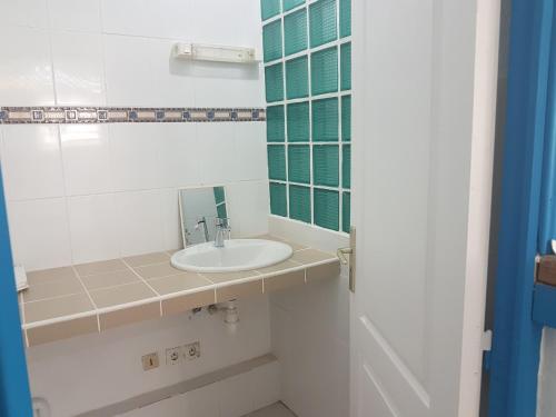 La salle de bains est pourvue d'un lavabo et d'un miroir. dans l'établissement RESIDENCE VERO, à Matoury