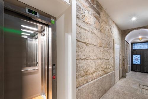 波多的住宿－City Center Modern Apartment in Porto，走廊上的电梯,有石墙