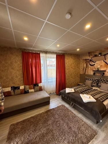 a bedroom with two beds and red curtains at Demizson Vendégház in Tokaj