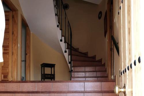 um corredor com escadas num edifício com uma cadeira em Casa Hidalgo em Baena
