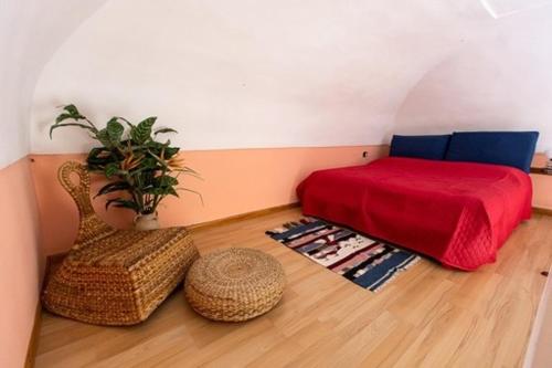 a bedroom with a red bed and a chair at La solution 2023 in Vico Equense