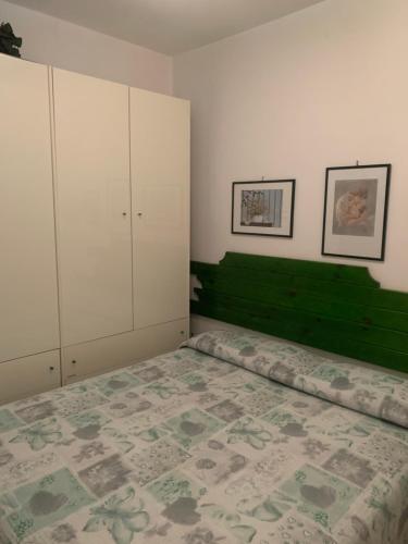 1 dormitorio con 1 cama grande y cabecero verde en Appartamento Albatros fronte spiaggia, en SantʼAlessio Siculo