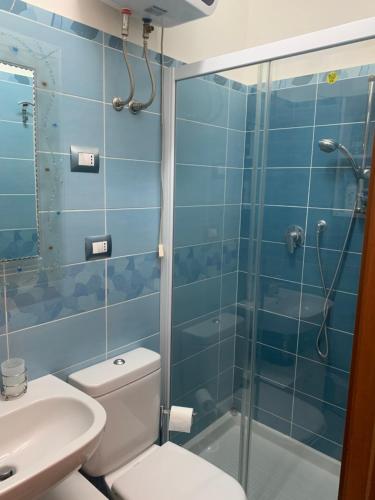 y baño con ducha, aseo y lavamanos. en Appartamento Albatros fronte spiaggia, en SantʼAlessio Siculo