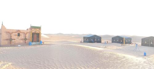 a group of tents in the sand in the desert at Camp Golden Desert Morocco in Mhamid