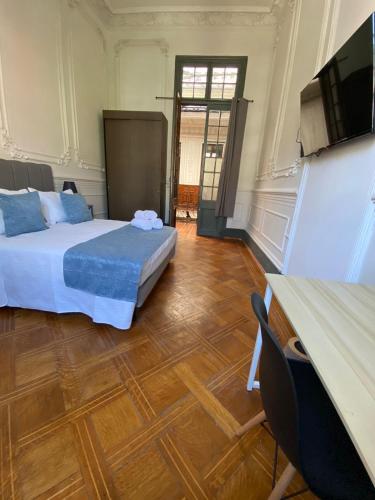 a room with two beds and a flat screen tv at Casa Marina Huérfanos in Santiago