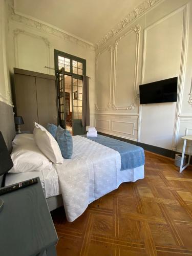 a bedroom with a large bed and a television at Casa Marina Huérfanos in Santiago