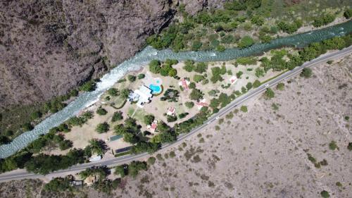 an aerial view of a house next to a river at Cabañas Del Sol in Valle Grande