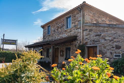 un viejo edificio de piedra con flores delante en A Cantina, en Mouromorto