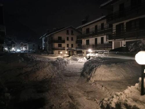 a street covered in snow at night with a street light at Mansarda in Morgex