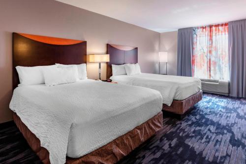 Fairfield Inn & Suites Columbus في كولومبوس: غرفة فندقية بسريرين ونافذة