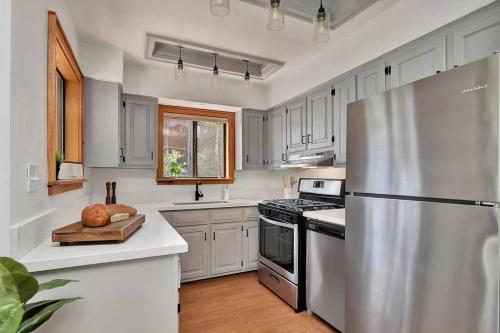 uma cozinha com armários brancos e um frigorífico de aço inoxidável em Mountain Cabin Retreat in the Pines em Prescott