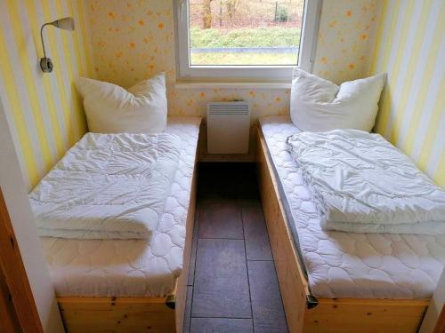 two beds in a small room with a window at Holiday home Tversted, Zarrentin in Zarrentin
