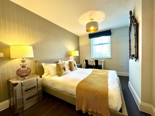 a bedroom with a bed and a table with a lamp at Super Trendy Apartment - Free Parking & Fast WiFi - 1 Minute walk to Poole Quay - Great Location - Free Parking - Fast WiFi - Smart TV - Newly decorated - sleeps up to 2! Close to Poole & Bournemouth & Sandbanks in Poole