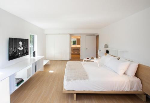 a white room with a bed and a tv at Beach Haus Bal Harbour in Miami Beach