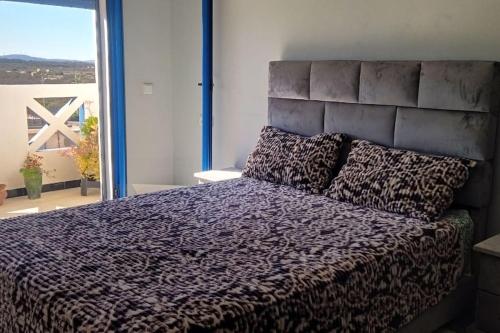 a bedroom with a large bed with a large window at Lovers & Surfers Room - 5 min To Beach in Essaouira