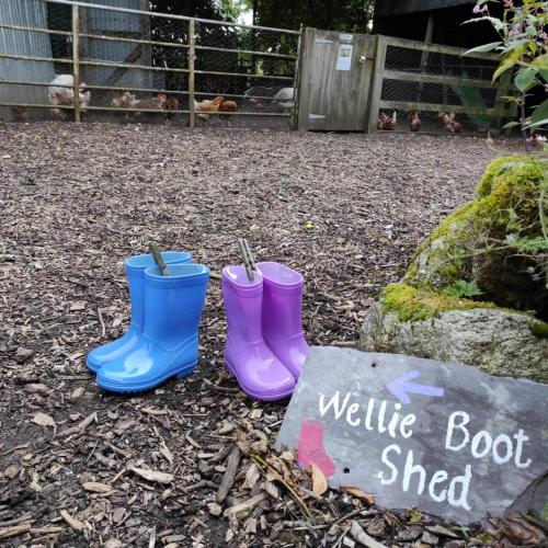 two pairs of rubber boots sitting next to a sign at Abhainn Ri Cottages in Blessington