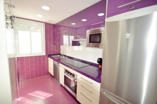 uma cozinha com paredes em azulejo roxo e um frigorífico em Fuengirola, Primera linea de playa em Fuengirola