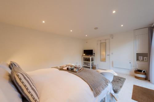 a bedroom with a large bed and a television at The retreat in West Mersea