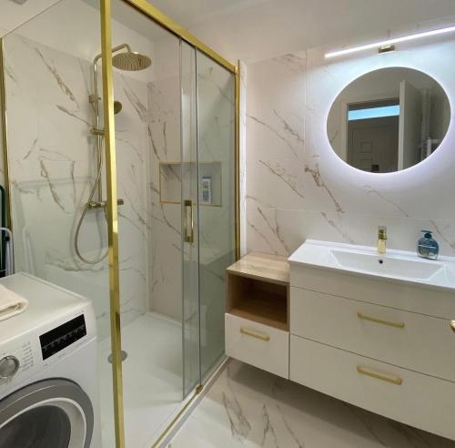 a bathroom with a shower and a sink and a washing machine at Sunshine Homes Zamárdi in Zamárdi