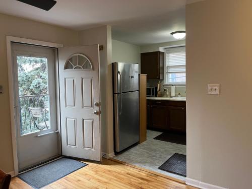 a kitchen with a refrigerator next to a door at Sunny 2 BR Apartment west of Chicago in quaint Forest Park center in Forest Park