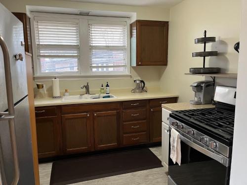 a kitchen with a sink and a stove at Sunny 2 BR Apartment west of Chicago in quaint Forest Park center in Forest Park