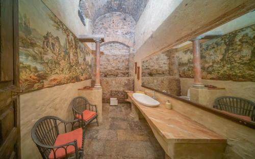 a bathroom with a sink and a large mirror at Palazzo Ronchelli in Castello Cabiaglio