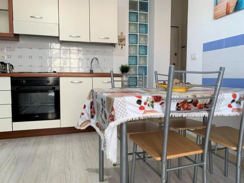 una cucina con tavolo, sedie e lavandino di Appartamento Aria di Mare a San Benedetto del Tronto