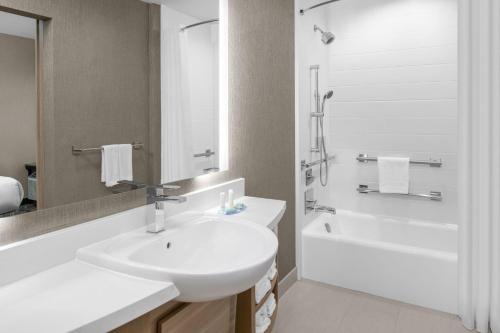a white bathroom with a sink and a bath tub at SpringHill Suites by Marriott Riverside Redlands in Redlands