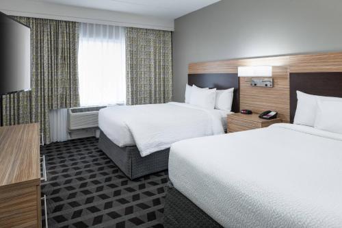 a hotel room with two beds and a television at TownePlace Suites by Marriott Orlando at SeaWorld in Orlando