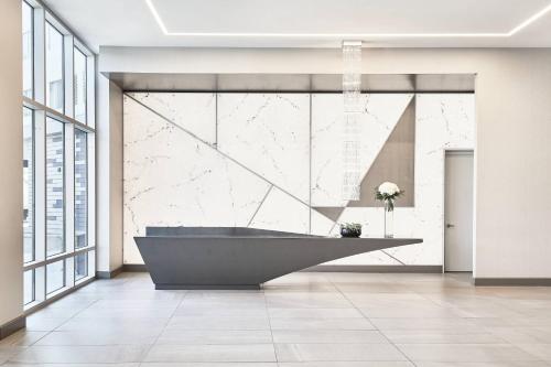 un bagno con una grande vasca in una stanza con finestre di AC Hotel by Marriott Los Angeles South Bay a Los Angeles
