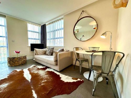 a living room with a couch and a table with a mirror at Beautiful Couples Retreat - FREE Parking & WiFi - 1 Minute walk to Poole Quay - Great Location - Free Parking - Fast WiFi - Smart TV - Newly decorated - sleeps up to 2! Close to Poole & Bournemouth & Sandbanks in Poole