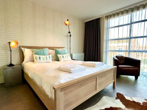a bedroom with a large bed and a chair at Beautiful Couples Retreat - FREE Parking & WiFi - 1 Minute walk to Poole Quay - Great Location - Free Parking - Fast WiFi - Smart TV - Newly decorated - sleeps up to 2! Close to Poole & Bournemouth & Sandbanks in Poole