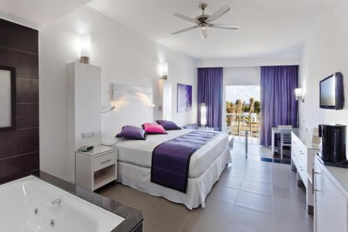 una habitación de hotel con una cama y una bañera en Riu Palace Mexico - All Inclusive, en Playa del Carmen