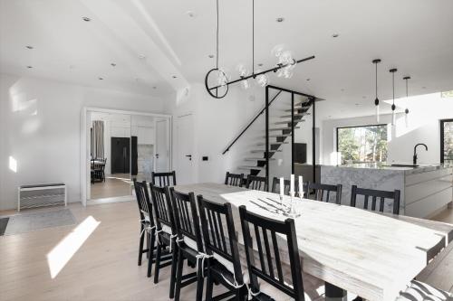 une salle à manger et une cuisine avec une grande table et des chaises en bois dans l'établissement Stylish and spacious family home, à Stockholm
