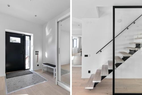 a staircase in a white house with a glass railing at Stylish and spacious family home in Stockholm