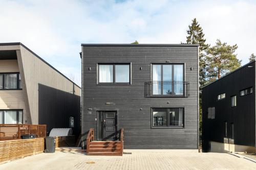 a black brick house with a balcony on it at Stylish and spacious family home in Stockholm