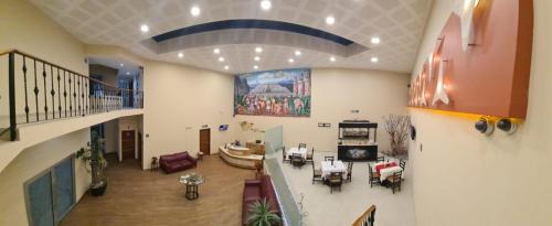 Großes Zimmer mit einem Wohnzimmer mit Tischen und Stühlen. in der Unterkunft HOTEL PLAZA PACHUCA in Zapotlán de Juárez