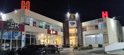 zwei Gebäude mit nachts auf einem Parkplatz geparkt in der Unterkunft HOTEL PLAZA PACHUCA in Zapotlán de Juárez