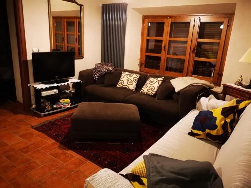 a living room with a couch and a tv at Casa del'Orto in Bigliolo