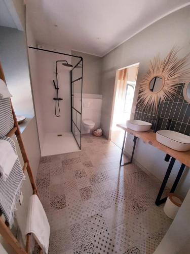 une salle de bain avec toilettes, lavabo et miroir dans l'établissement P'tit cocon au cœur du Lot avec piscine, à Dégagnac