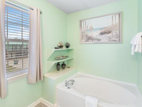 La salle de bains est pourvue d'une baignoire et d'une fenêtre. dans l'établissement Beach home in the Cherry Grove, à Myrtle Beach