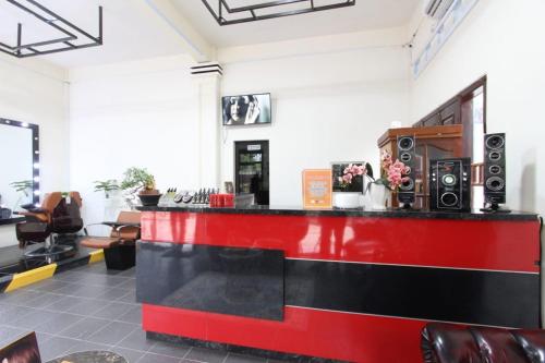 einen Salon mit einer roten und schwarzen Theke mit Lautsprechern in der Unterkunft Jaka Homestay in Rembang